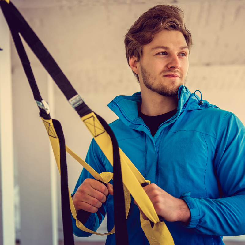 Young man holding TRX bands | DeHenzel Training Systems Young man holding TRX bands