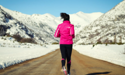 woman running down run in snow-capped mountains | DeHenzel Training Systems woman running down run in snow-capped mountains